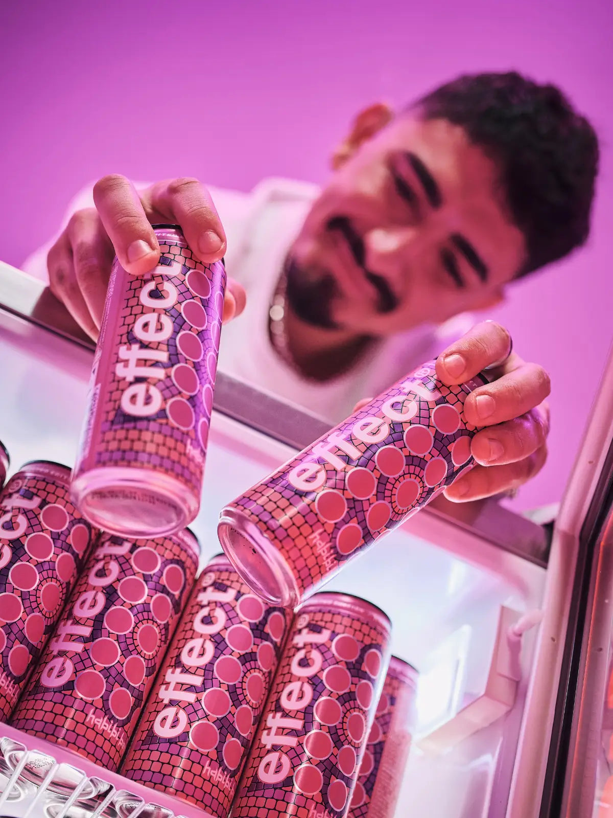 ein mann holt effect habibi berry dosen aus einem kühlschrank