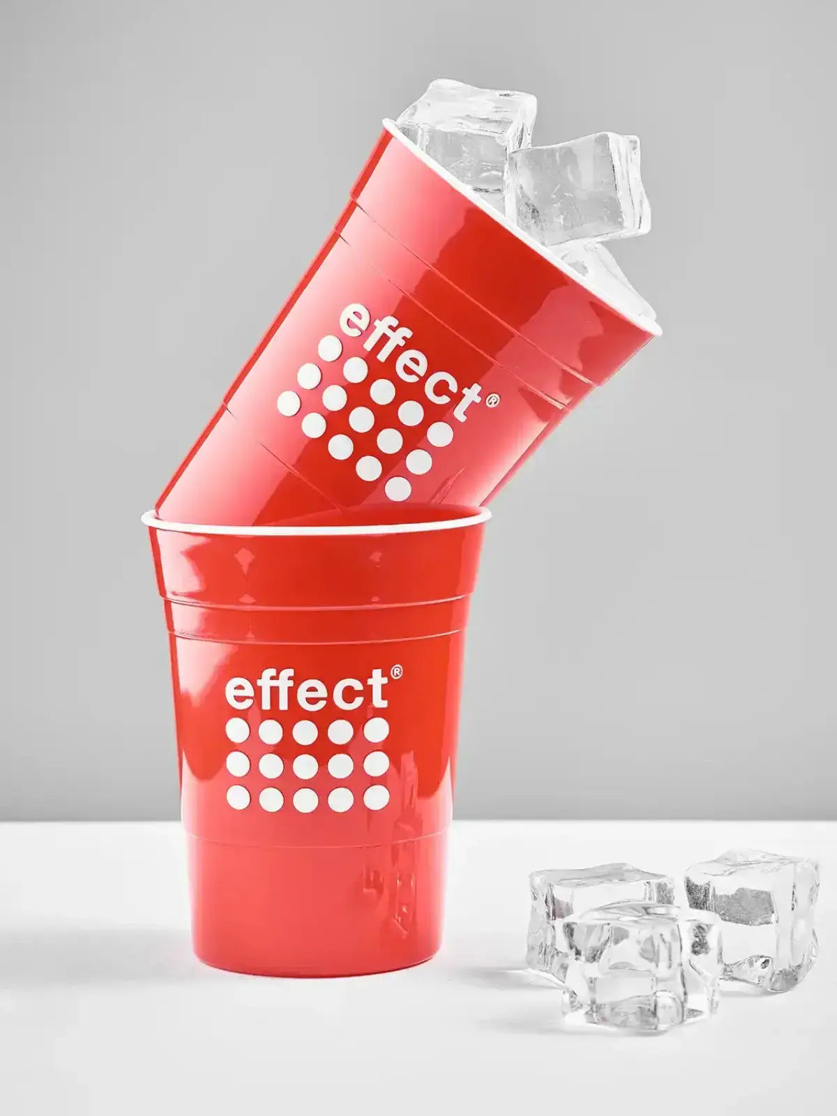 2 Rote effect Becher die halb ineinander stehen. Ein Becher ist mit Eiswürfeln befüllt