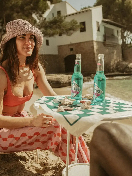 Ein Frau sitzt am Tisch und trinkt eine Flasche SALITOS Blue