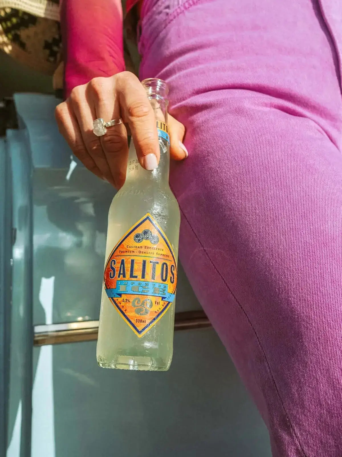 Eine Frau die eine Flasche SALITOS Ice in der Hand hält