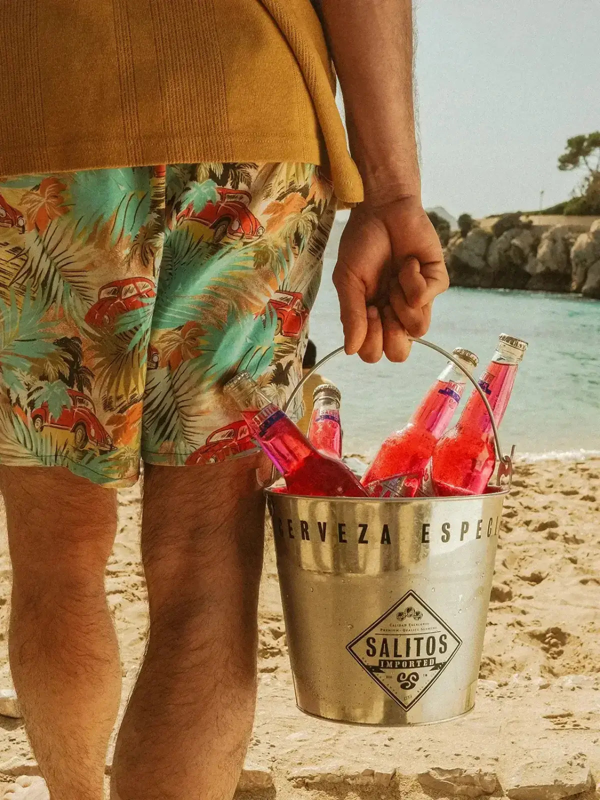 Ein Mann der am Strand einen Eimer gefüllt mit SALITOS Pink trägt