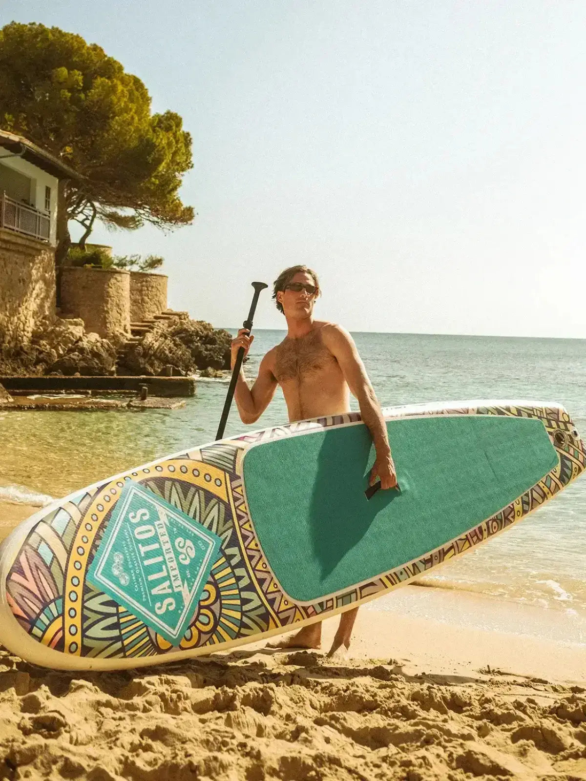 Ein Mann am Strand mit türkisen Salitos Stand up Board